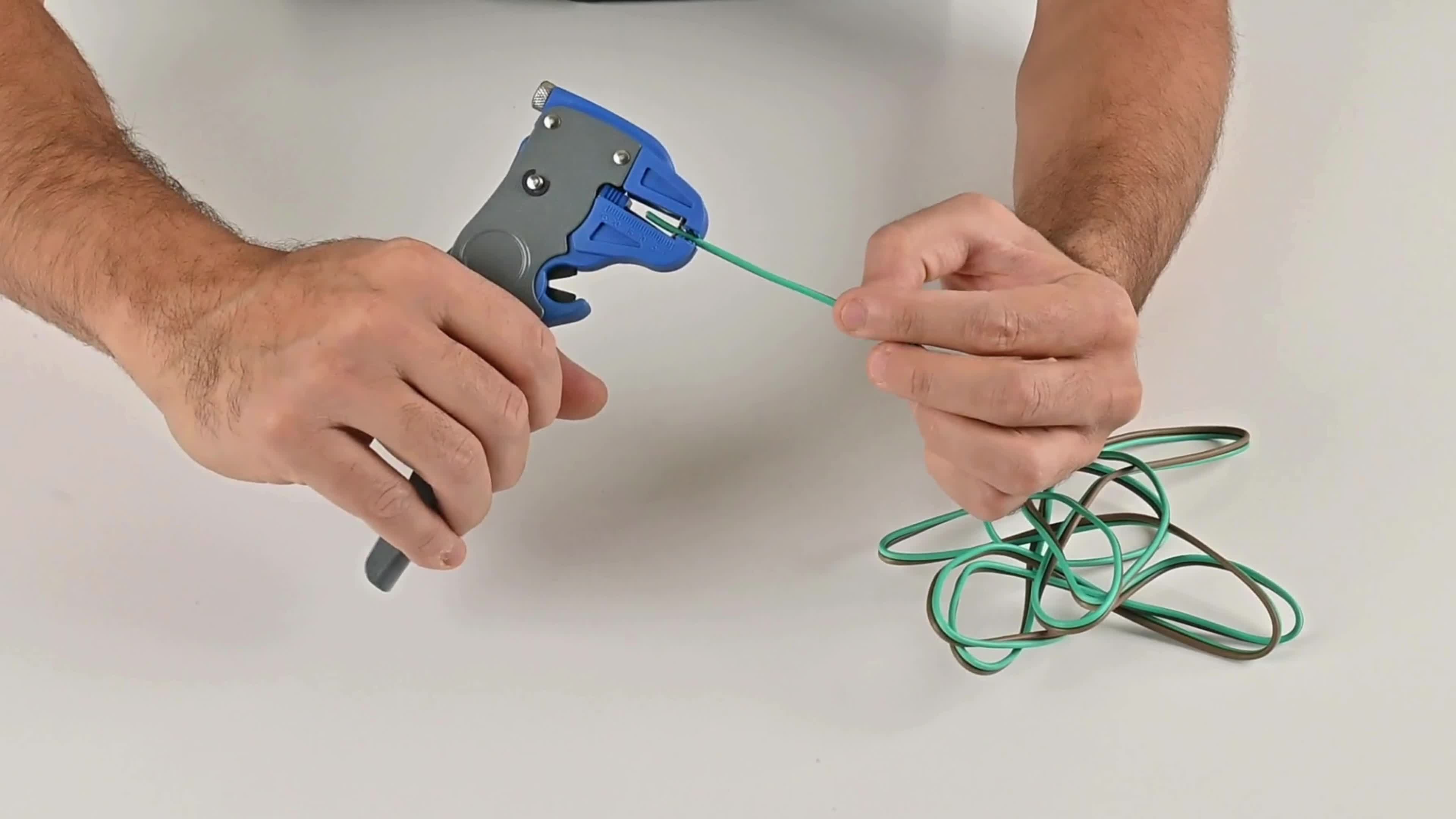 Trailer wire being inserted into the jaws of an automatic wire stripper.